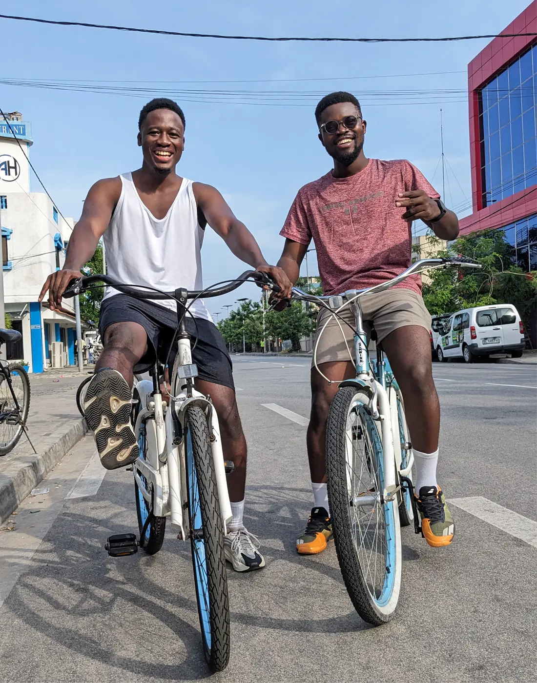 Deux clients Koin Koin Vélo sur leurs vélos dans une rue de Cotonou